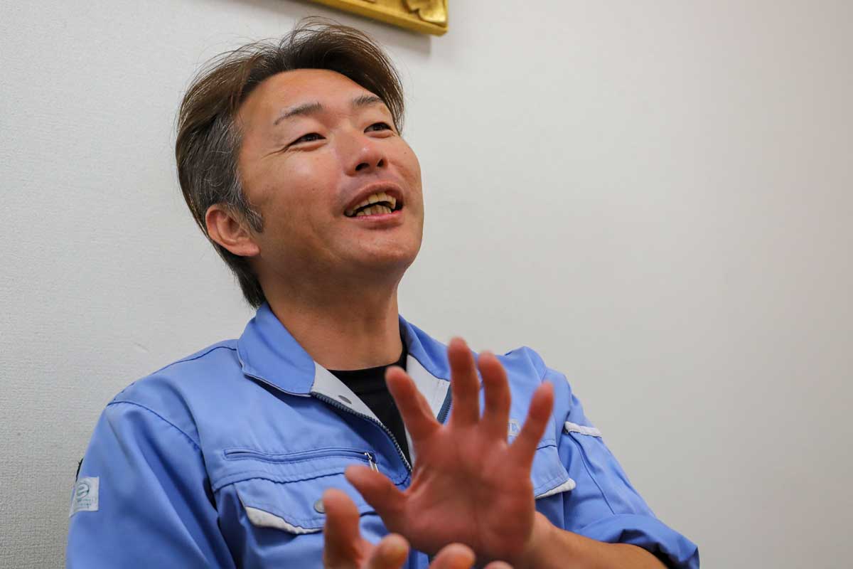 青い作業服で話す相和の社員